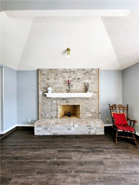 living area featuring a fireplace, lofted ceiling, and dark hardwood / wood-style floors