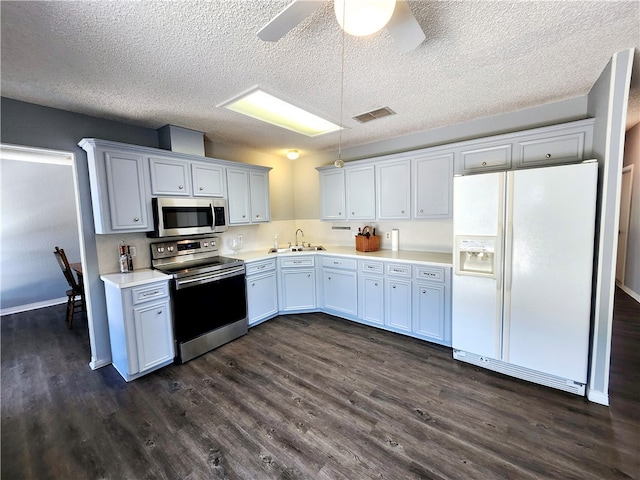 kitchen with ceiling fan, appliances with stainless steel finishes, dark hardwood / wood-style floors, and white cabinets