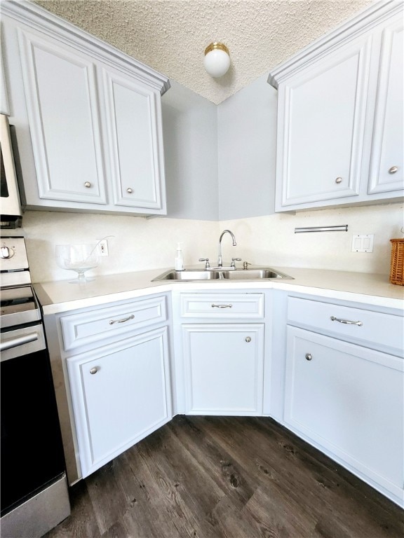 kitchen featuring sink, dark hardwood / wood-style floors, a textured ceiling, range, and white cabinets