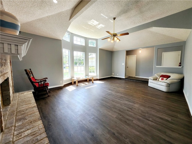 unfurnished living room featuring lofted ceiling, a textured ceiling, dark hardwood / wood-style floors, and a fireplace