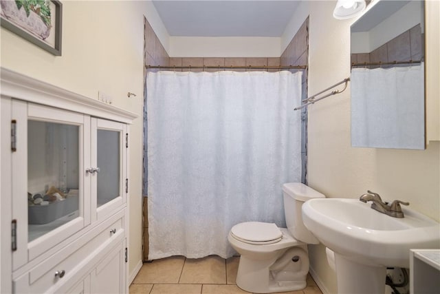 bathroom with tile patterned flooring, toilet, and walk in shower