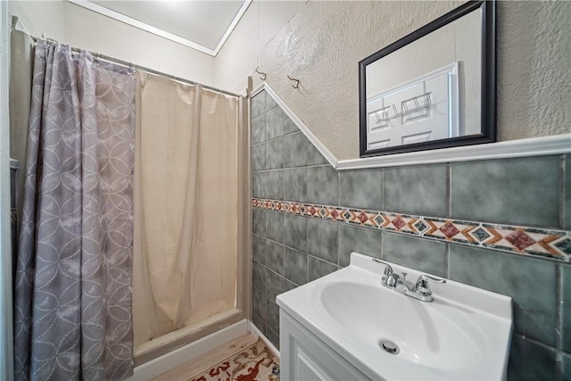 bathroom featuring vanity, curtained shower, crown molding, and tile walls