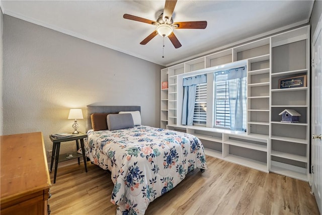 bedroom with ceiling fan, crown molding, and light wood-type flooring