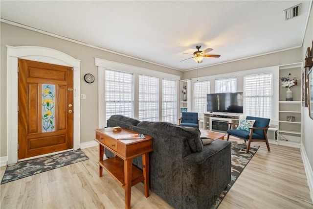 living room featuring ceiling fan, light wood-type flooring, and ornamental molding