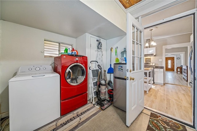 washroom featuring washing machine and clothes dryer and a chandelier