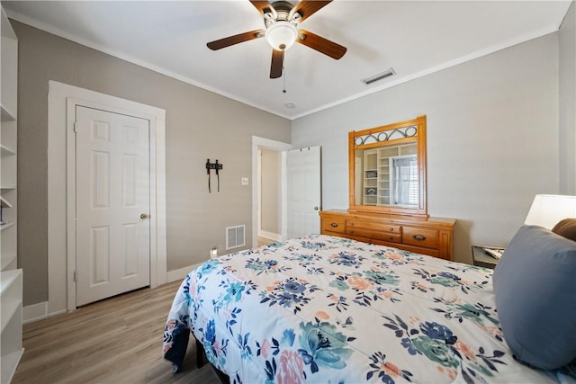 bedroom with light hardwood / wood-style floors, ceiling fan, and crown molding