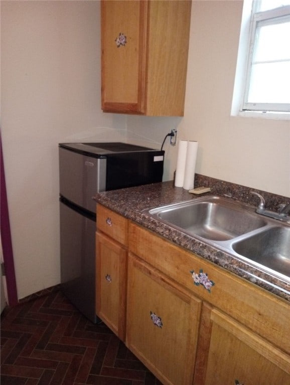 kitchen featuring sink and stainless steel refrigerator