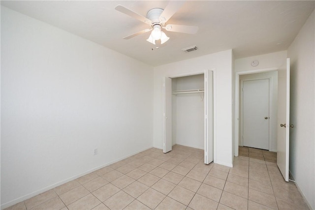 unfurnished bedroom with a closet, a ceiling fan, light tile patterned flooring, and visible vents