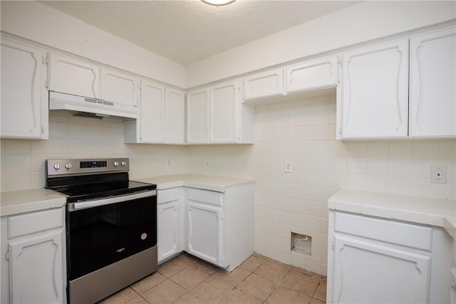 kitchen with electric stove, white cabinetry, light tile patterned floors, and under cabinet range hood