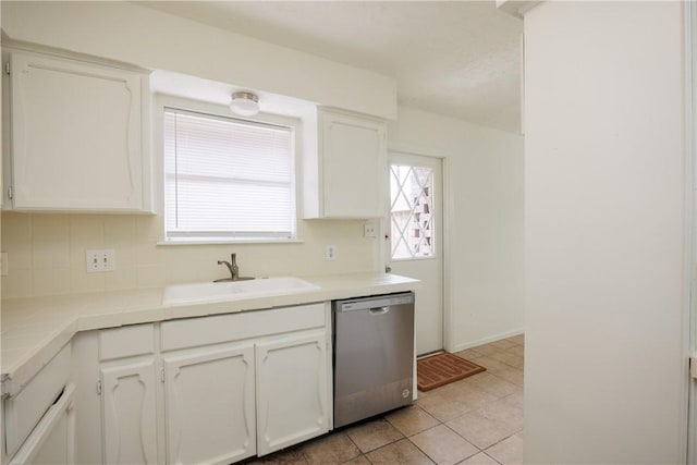 kitchen with white cabinets, light tile patterned flooring, a sink, backsplash, and stainless steel dishwasher
