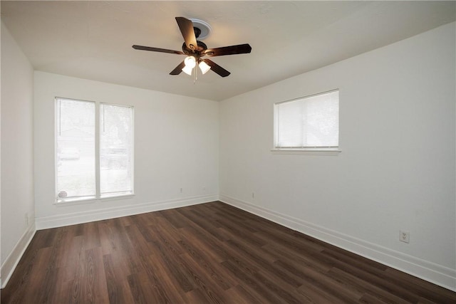 spare room featuring baseboards, dark wood-type flooring, and ceiling fan