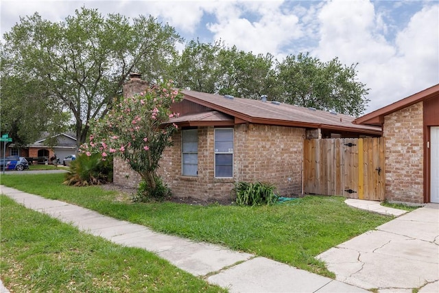 view of property exterior featuring a lawn, brick siding, fence, and a chimney