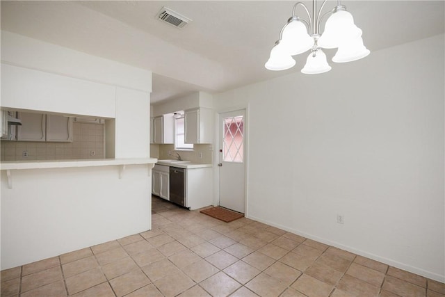 kitchen with visible vents, light countertops, dishwasher, and a notable chandelier