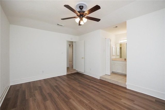unfurnished bedroom featuring baseboards, wood finished floors, and visible vents