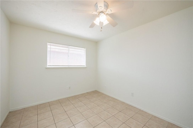 empty room featuring a ceiling fan, baseboards, and light tile patterned floors
