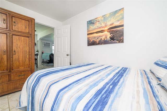 bedroom featuring light marble finish flooring and a wall unit AC