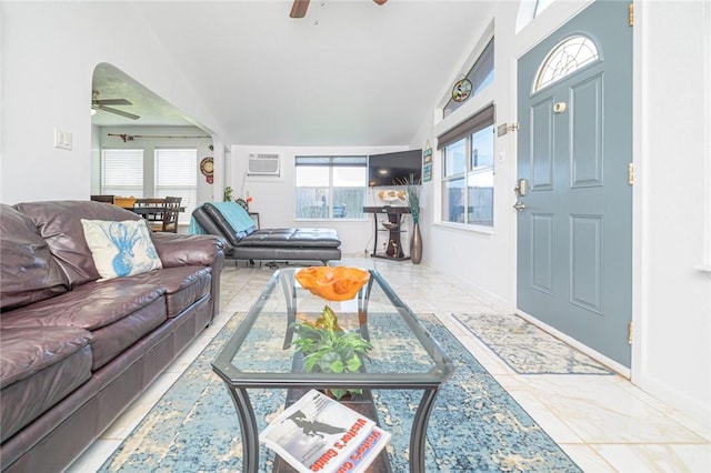 living room featuring ceiling fan, marble look tiles, a wall mounted AC, and baseboards