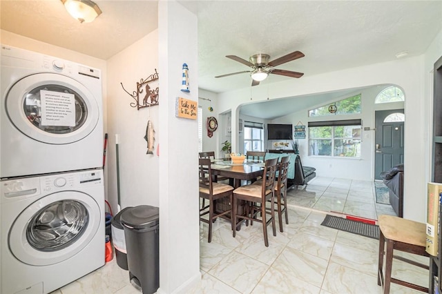 washroom featuring stacked washer / drying machine, marble finish flooring, and ceiling fan