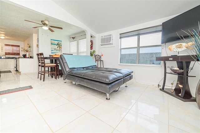 living room with a wall mounted air conditioner, a ceiling fan, and light tile patterned floors