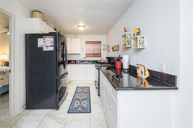 kitchen with black appliances, light marble finish flooring, a sink, white cabinets, and ceiling fan