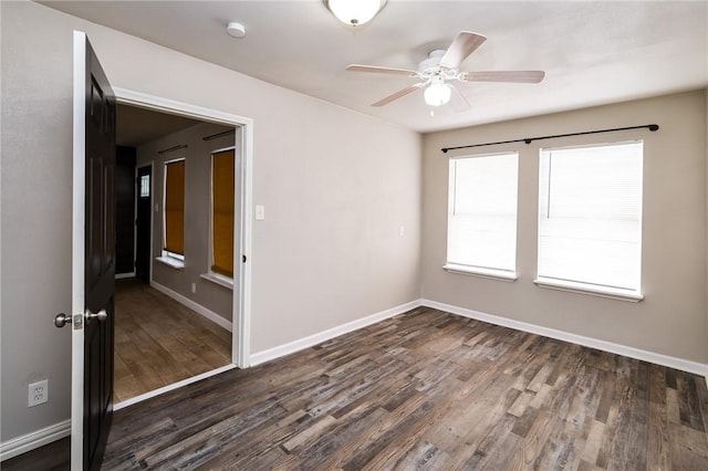 empty room with ceiling fan and dark wood-type flooring