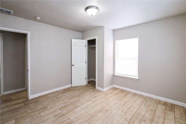 unfurnished bedroom with light wood-type flooring and a closet