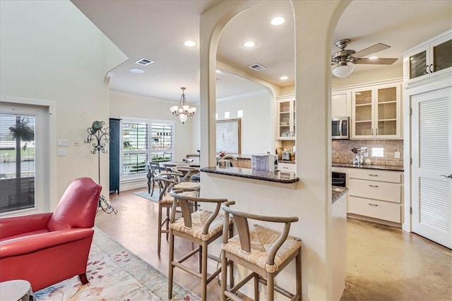 403 Marina Dr, Port Aransas, TX 78373 - kitchen featuring stainless steel microwave, arched walkways, concrete floors, tasteful backsplash, and recessed lighting