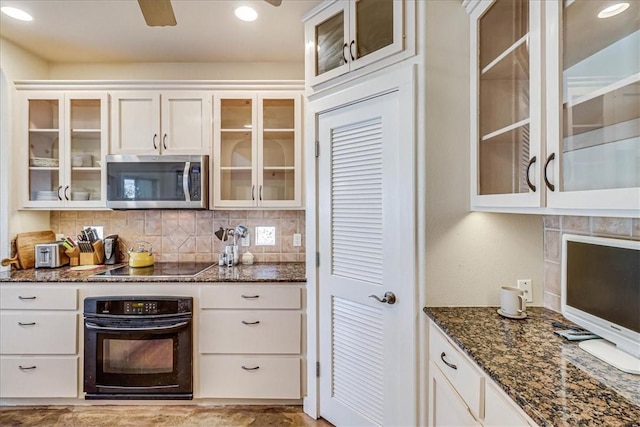 403 Marina Dr, Port Aransas, TX 78373 - kitchen with black appliances, dark stone counters, backsplash, glass insert cabinets, and white cabinets