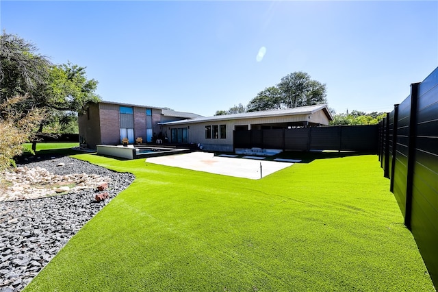 rear view of house with a lawn and a patio