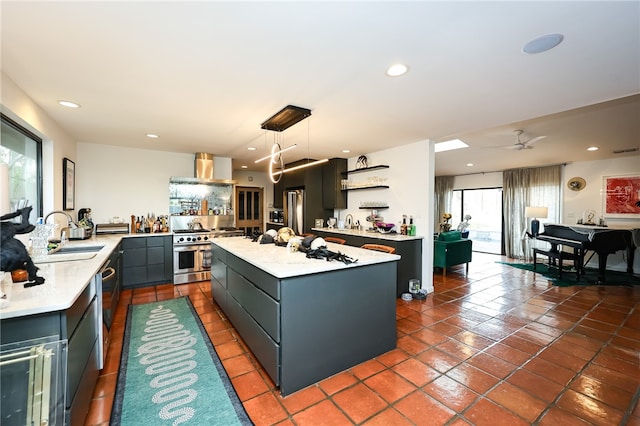 kitchen featuring premium appliances, a center island, hanging light fixtures, and plenty of natural light