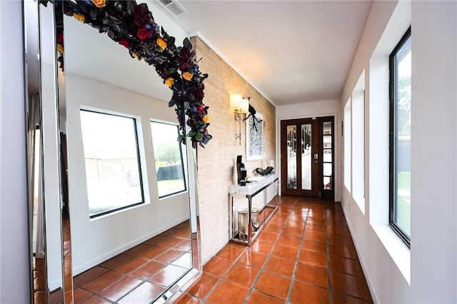 entryway with brick wall and tile patterned floors