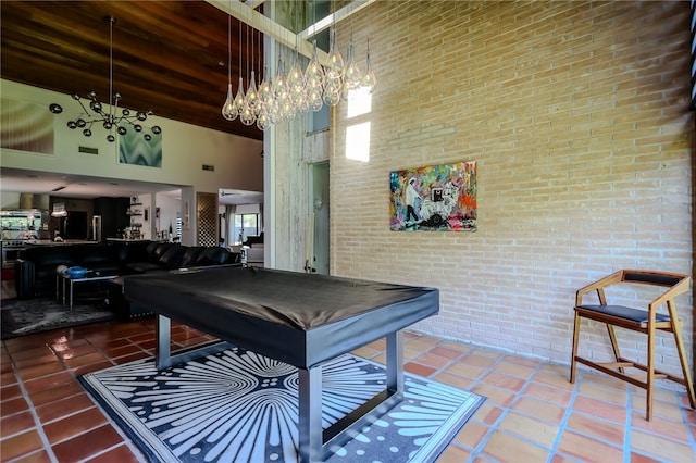 playroom with pool table, a chandelier, tile patterned floors, and a towering ceiling