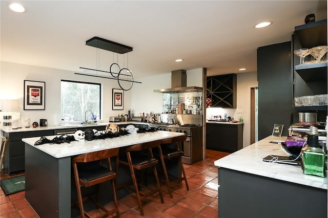 225 Chenoweth Dr, Corpus Christi, TX 78404 - kitchen featuring wall chimney exhaust hood, high end stainless steel range oven, a center island, recessed lighting, and a kitchen bar