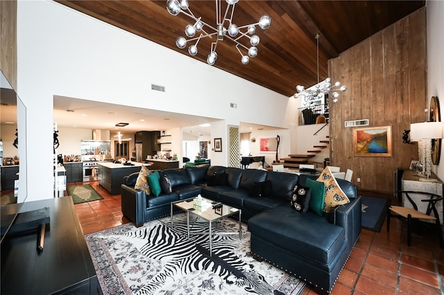 living room with high vaulted ceiling, wooden walls, a chandelier, and wood ceiling