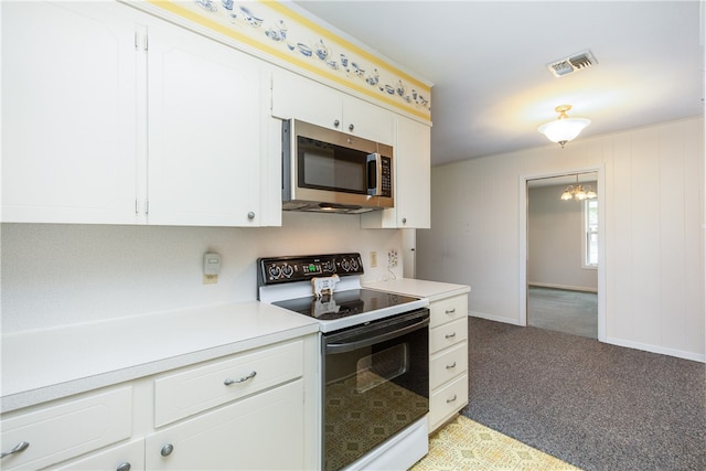 kitchen with white range with electric stovetop, a notable chandelier, light carpet, and white cabinets