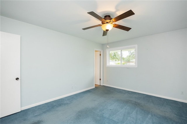 spare room with dark colored carpet and ceiling fan