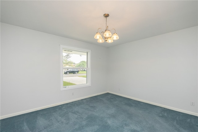 carpeted spare room featuring an inviting chandelier