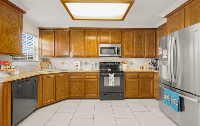 kitchen with light tile patterned flooring, sink, crown molding, decorative backsplash, and black appliances