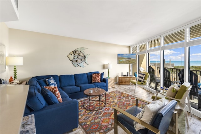 living room featuring a water view, expansive windows, and hardwood / wood-style floors