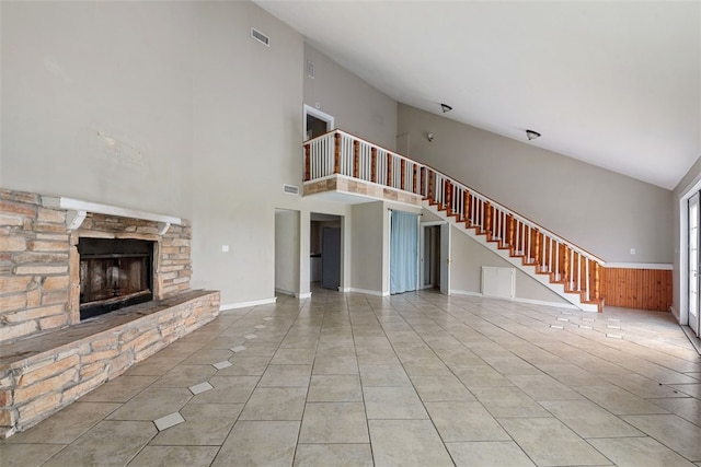 unfurnished living room with light tile patterned floors, a fireplace, and vaulted ceiling