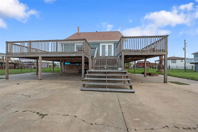 rear view of house featuring a carport, a deck, and french doors