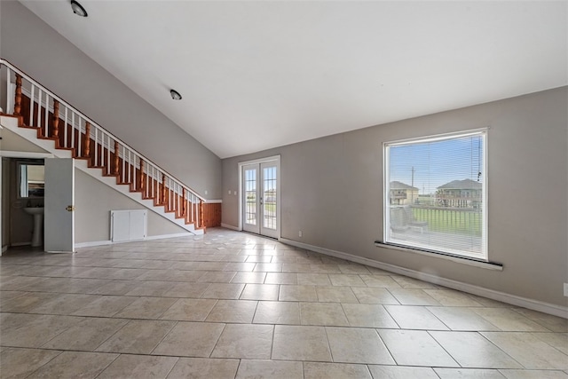 unfurnished living room featuring lofted ceiling, light tile patterned floors, and french doors