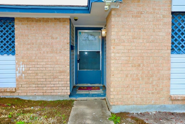 view of exterior entry featuring brick siding