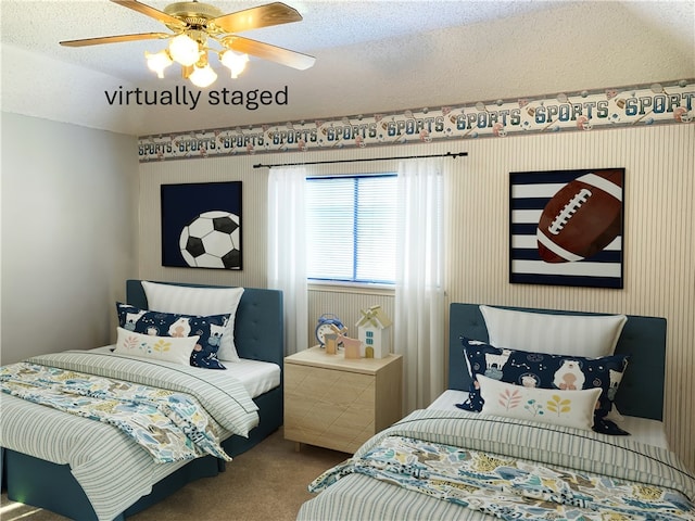 carpeted bedroom featuring ceiling fan and a textured ceiling