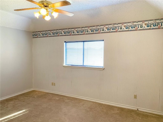 carpeted empty room featuring ceiling fan, a textured ceiling, and vaulted ceiling