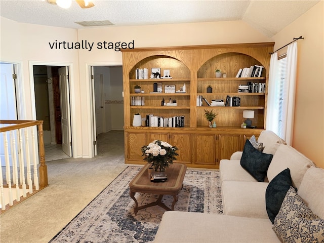 living room featuring vaulted ceiling, a textured ceiling, and light carpet