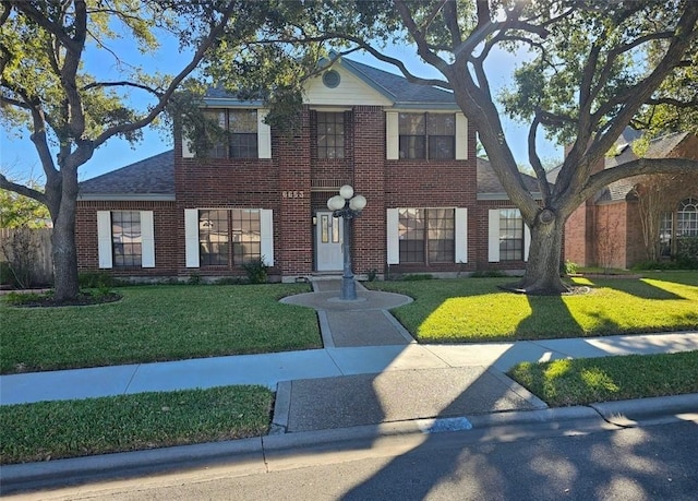 colonial-style house featuring a front lawn