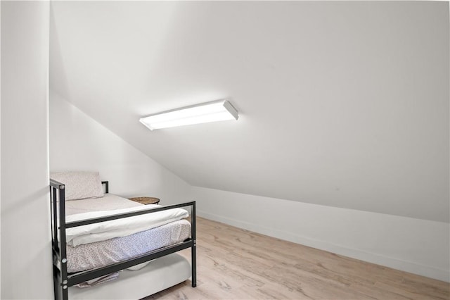 bedroom with lofted ceiling and light wood-type flooring