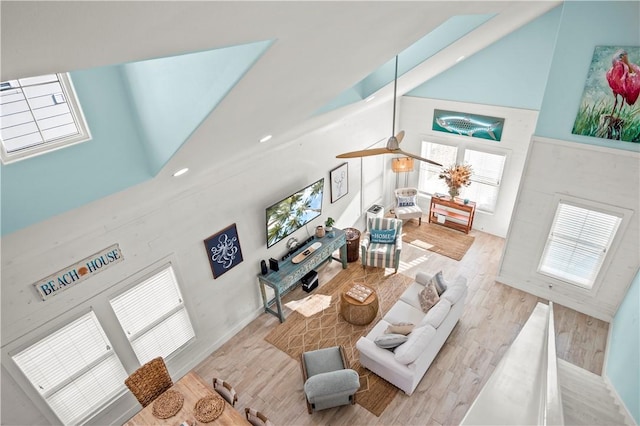 living room featuring high vaulted ceiling and light hardwood / wood-style floors