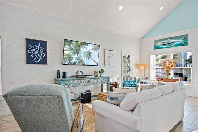 living room with light hardwood / wood-style flooring and high vaulted ceiling